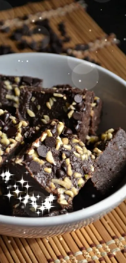 Bowl of chocolate brownies topped with nuts and chocolate chips.