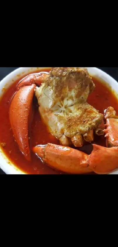 Vibrant crab dish with red sauce in a white bowl.