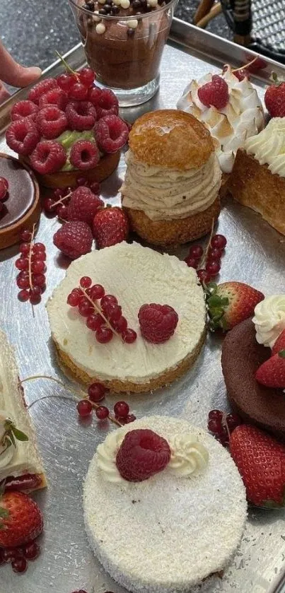 A variety of desserts with berries on a silver tray, perfect for sweet indulgence.