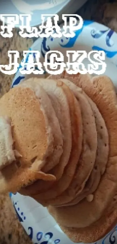 Stack of flapjacks on a paper plate with decorative design.