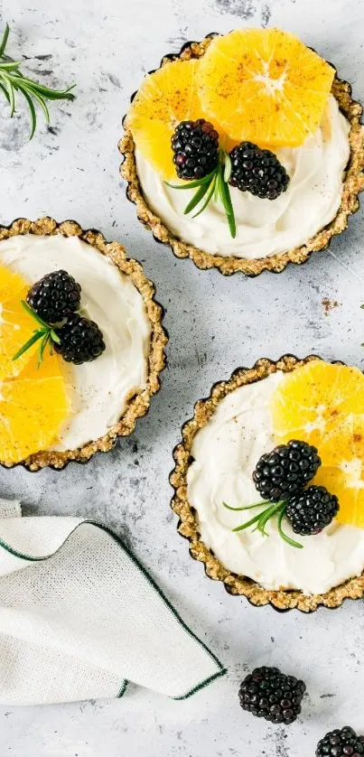 Fruit tarts with berries and oranges on a white plate.