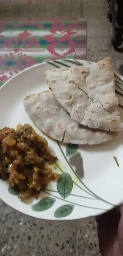 Indian flatbread with vegetable dish on decorative plate.