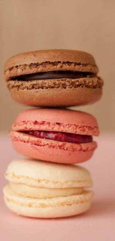 A stack of colorful macarons on a pink background.