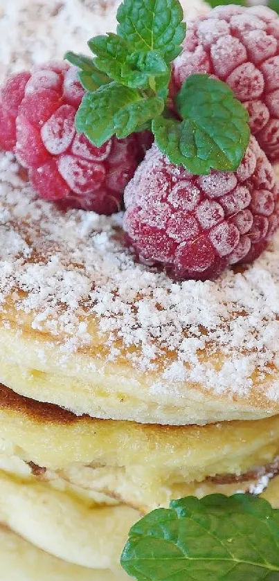 Fluffy pancakes topped with raspberries and sugar.