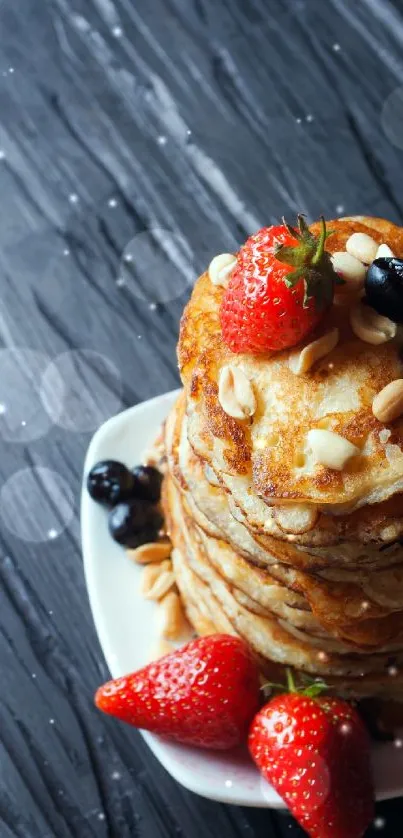 Stack of pancakes with strawberries and blueberries on a dark background.