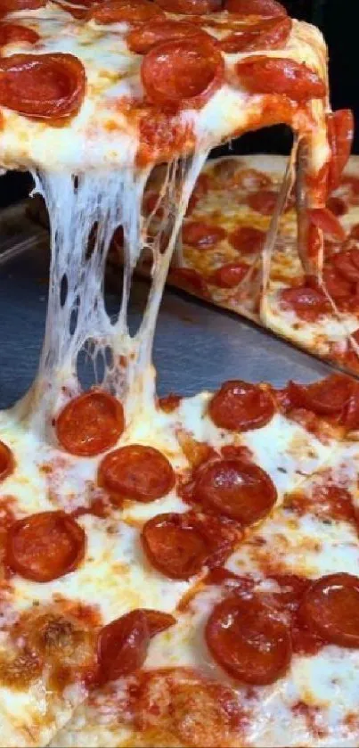 A slice of pepperoni pizza with melting cheese being lifted.