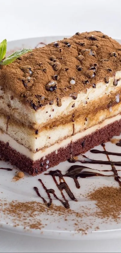 Tiramisu dessert with chocolate drizzle on a white plate.