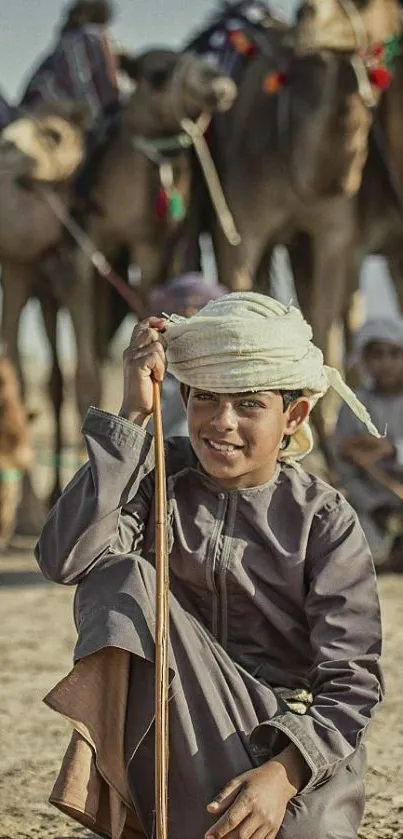 Young boy with camels in desert landscape.