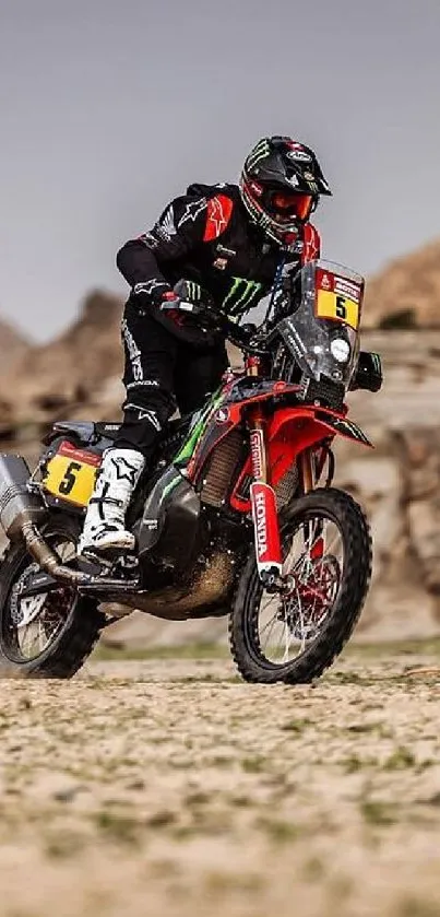 Rider on a dirt bike racing through rugged desert terrain with a rocky backdrop.