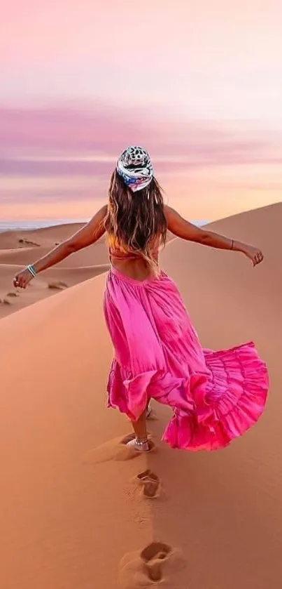 Woman in pink dress walking on desert dunes during sunset.