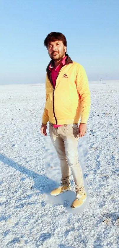 Person standing in vast snowy desert under blue sky.