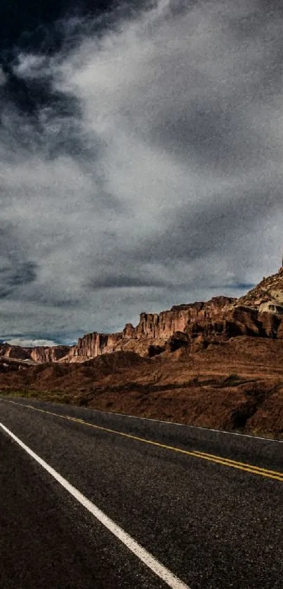 Desert road with towering cliffs under a dramatic sky, perfect for travel lovers.