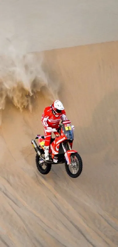 Motorcyclist racing down desert sand dune with billowing dust.