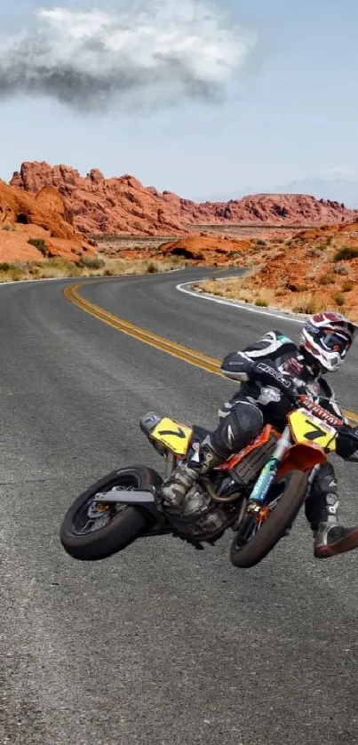 Motorbike on winding desert road with orange rocks under a cloudy sky.