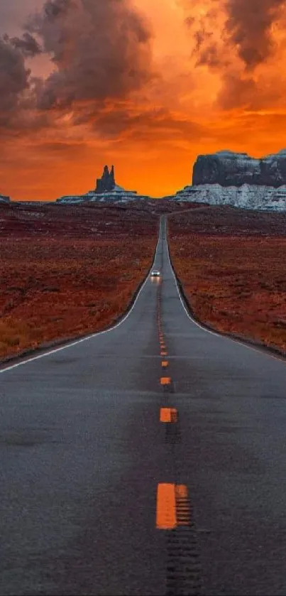 Dramatic desert road leading to horizon at sunset with vivid orange sky.