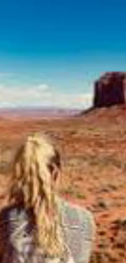 Woman gazing at desert rock formation under a clear blue sky.