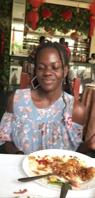 Woman in floral dress dining in a vibrant restaurant.