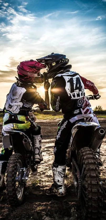 Two motocross riders at sunset on dirt bikes, capturing adventure.