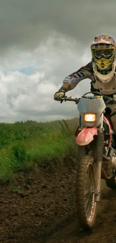 Rider on dirt bike racing through lush, green trails beneath a cloudy sky.