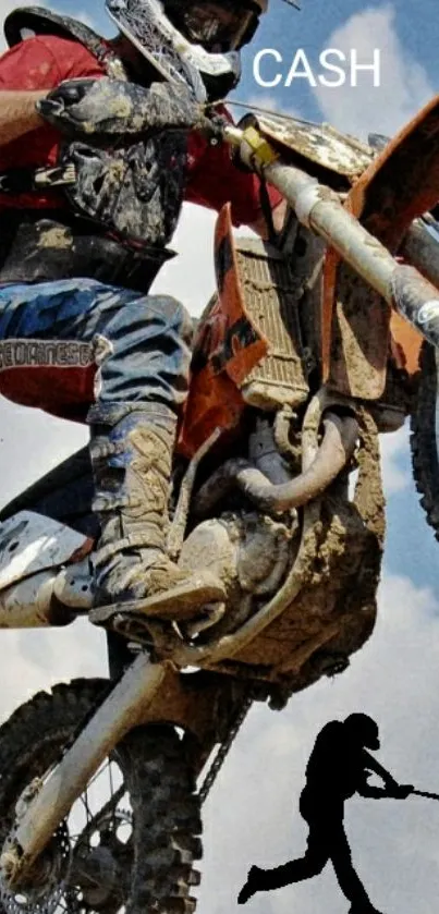 Motocross rider airborne on a dirt bike against blue sky.