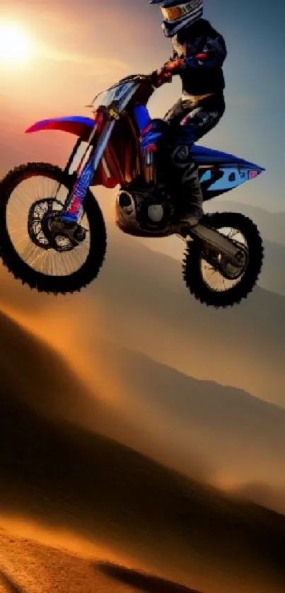 Dirt biker jumps over a sandy hill at sunset.