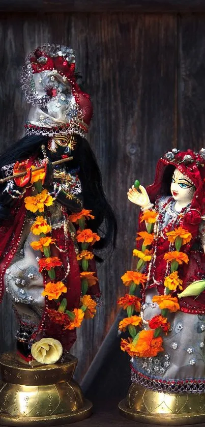 Divine couple statue on wooden background with colorful garlands.