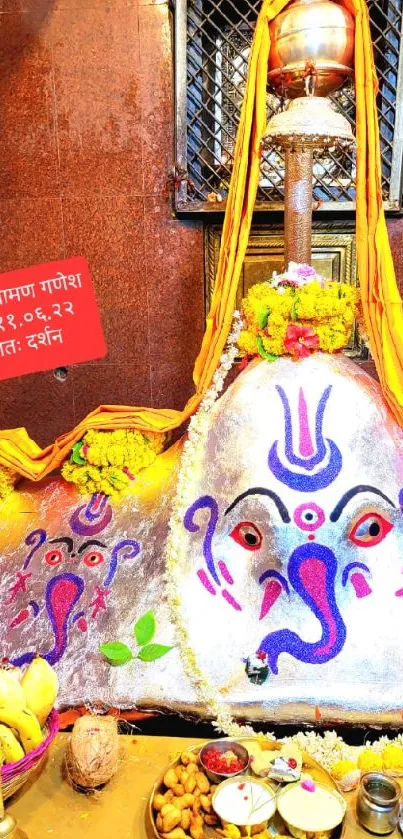 Vibrant Ganesh temple adorned in colorful decor with offerings.