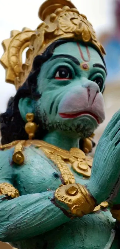 Close-up of a decorative Hanuman statue with teal and gold details.