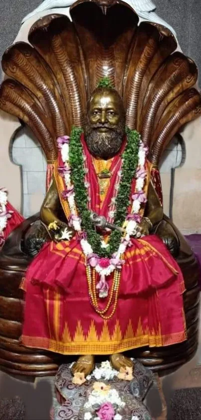 Ornate deity statue with vibrant garlands.