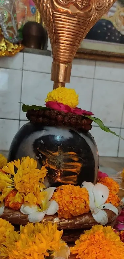 Shiva Lingam with marigold flowers and cobra sculpture.