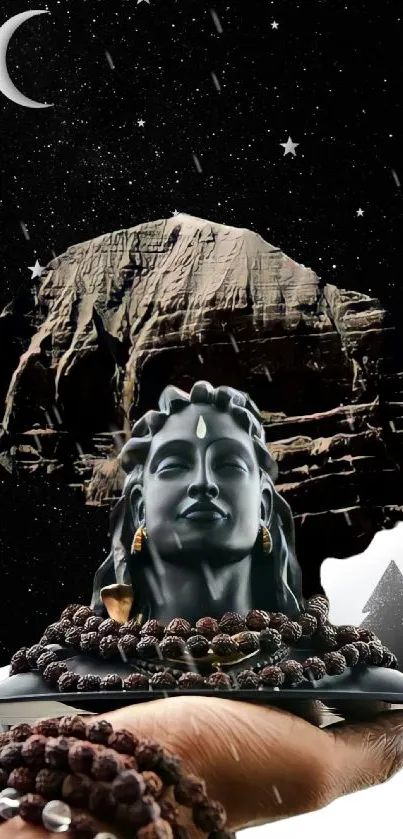 Shiva statue against a starry night sky, held in a hand.