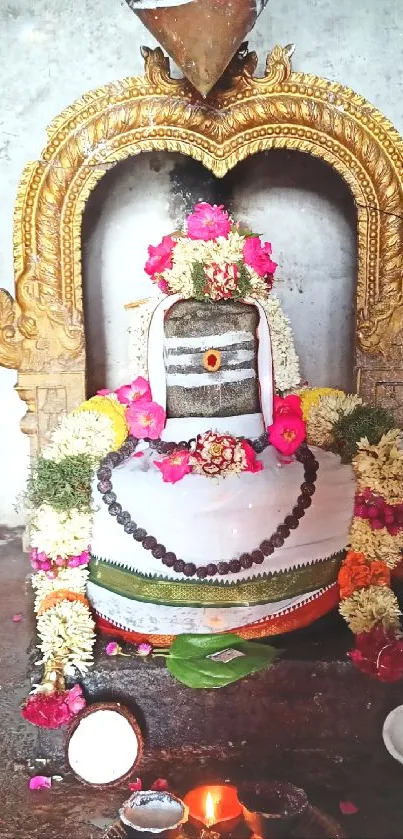 Adorned Shivling with flowers and lamps in a temple setting.