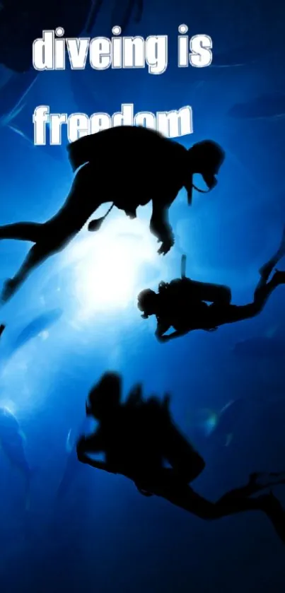 Silhouetted divers explore a vibrant blue ocean.