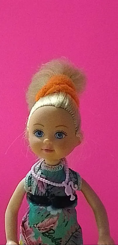 Doll with colorful dress on a pink background.