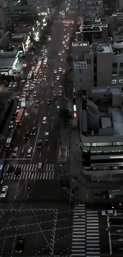 Aerial view of a bustling city street at night, with traffic and illuminated buildings.