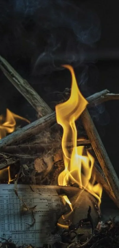 Wallpaper of intense flames with burning wood in a dramatic dark setting.