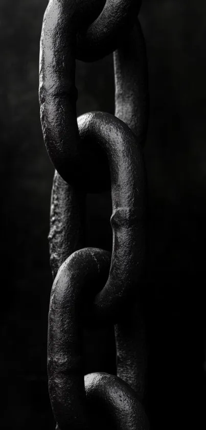 Close-up of a black chain link on a dark background.