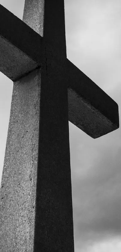 Black and white cross silhouette against cloudy sky.