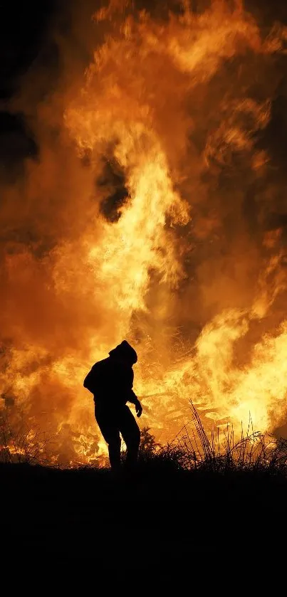 Silhouette in front of a towering fire at night, creating dramatic visuals.