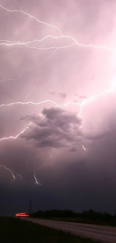 Dramatic lightning storm over dark road at night.