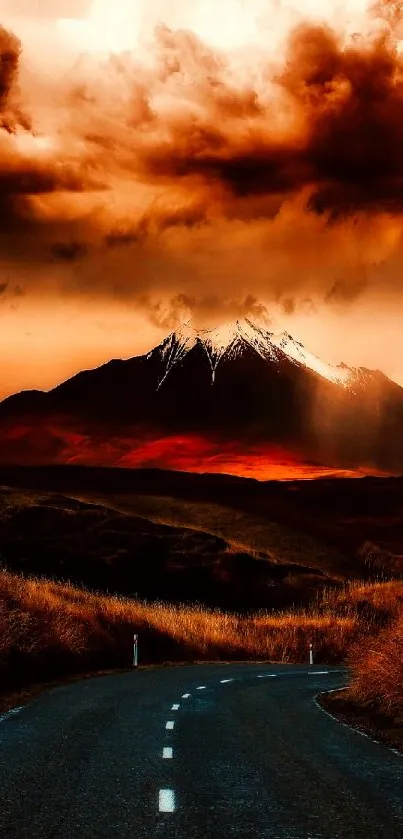 Fiery sunset over mountains with winding road.