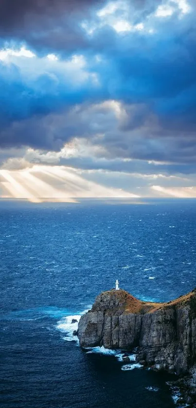 Lighthouse on cliffs with dramatic ocean and cloudy sky.