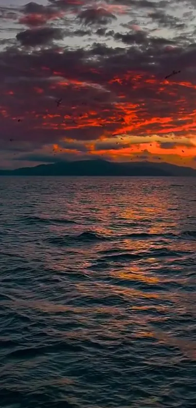 Dramatic ocean sunset with red skies reflecting on the sea.