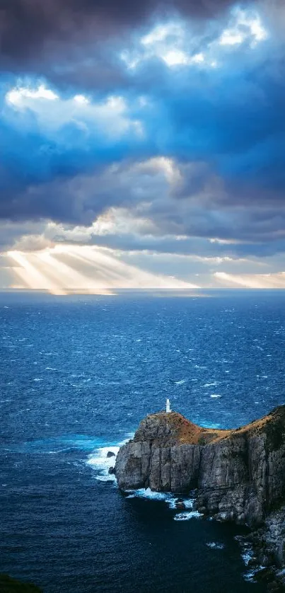 Dramatic ocean view with sunlight through clouds over a scenic rocky coastline.