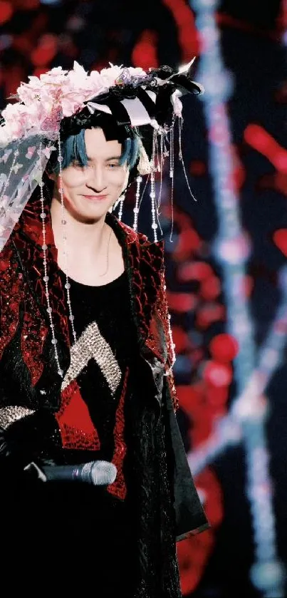 Charismatic performer in red and black attire with a unique headpiece.