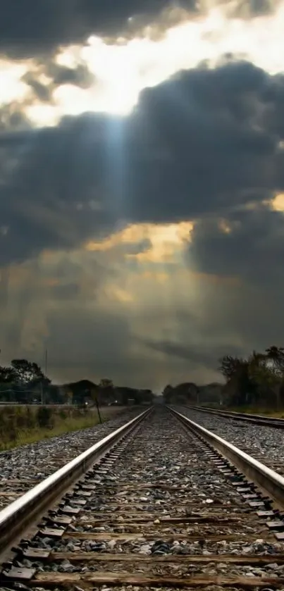 Dramatic railway under stormy skies with sunlight breaking through clouds.