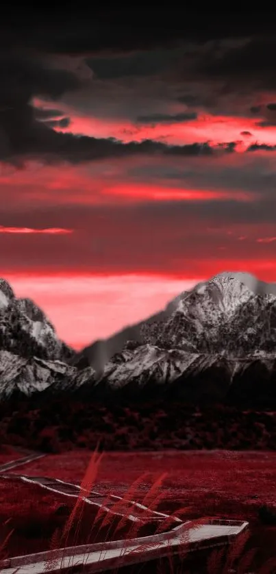 Red sunset over snowy mountains with dramatic clouds.