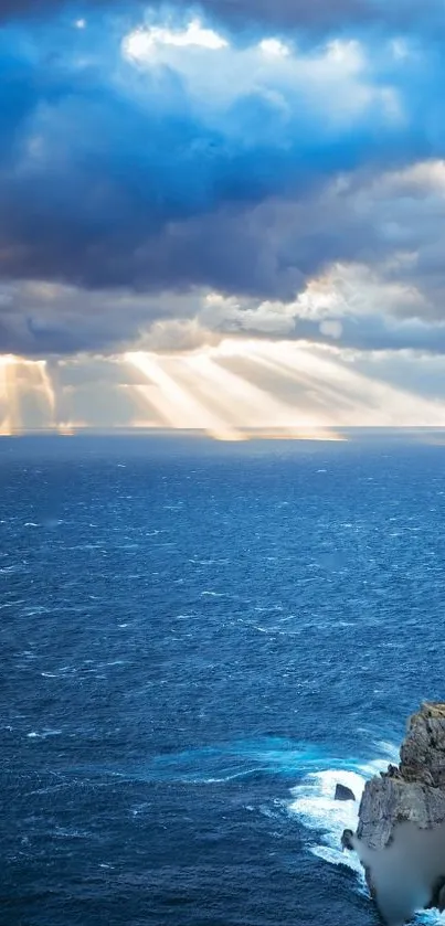 Dramatic sea and sky with cliffs and sunlight breaking through clouds.