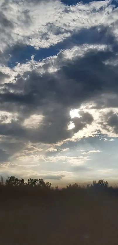 Dramatic cloudy sky with shades of blue and sunlight peeking through.