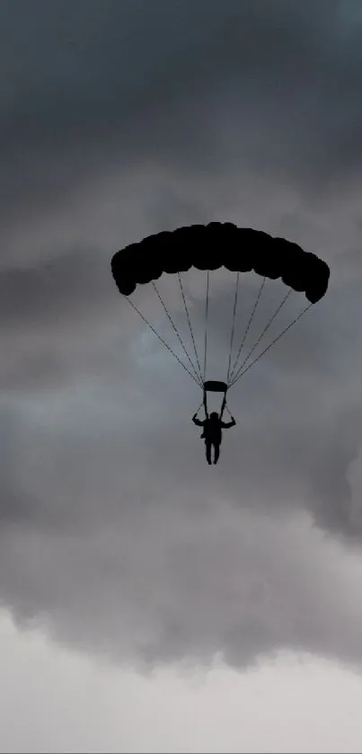 Skydiver silhouette against stormy clouds wallpaper.